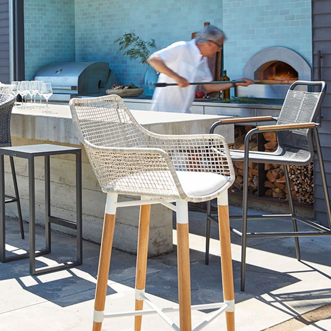 outdoor kitchen and pizza oven with bar chairs in foreground for mobile