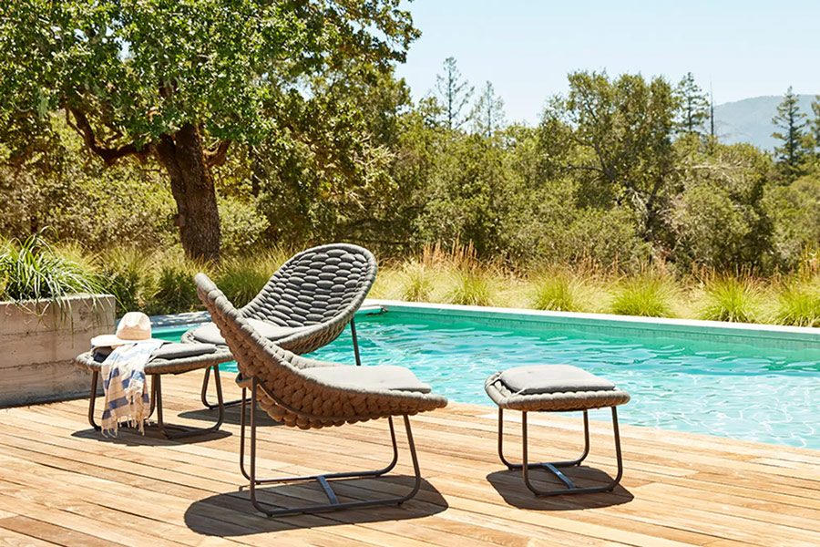 cloud lounge chairs and ottomans in backyard oasis by pool