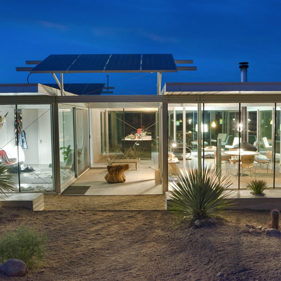 night view of Pioneertown IT house with glass walls and solar panels in view for mobile