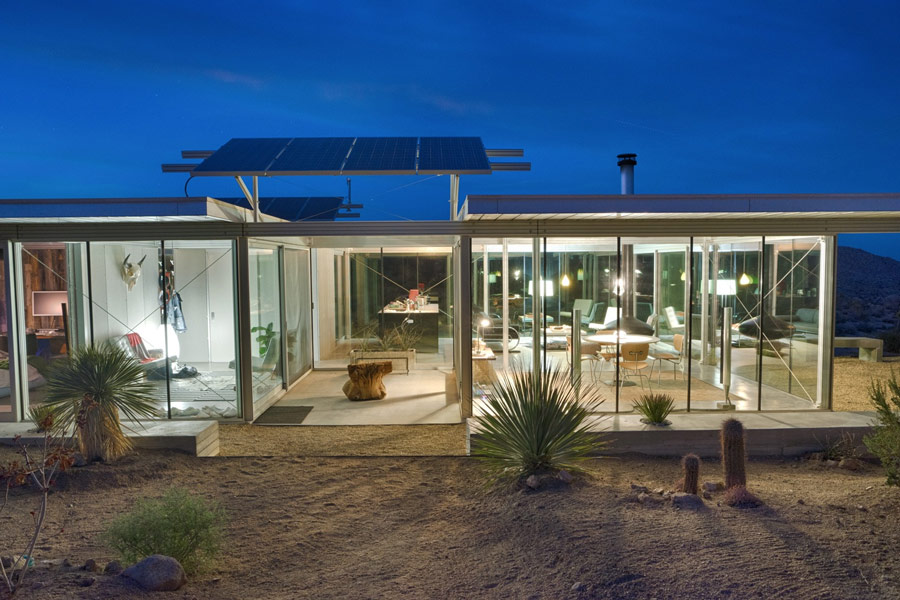 night view of Pioneertown IT house with glass walls and solar panels in view