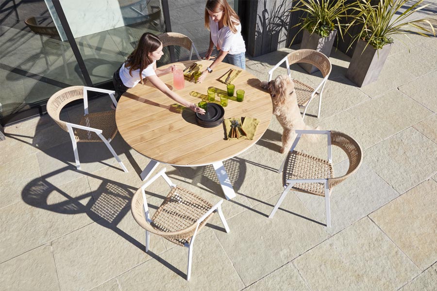 The Portola dining table and chairs, built with aluminum frames, teak and woven rope