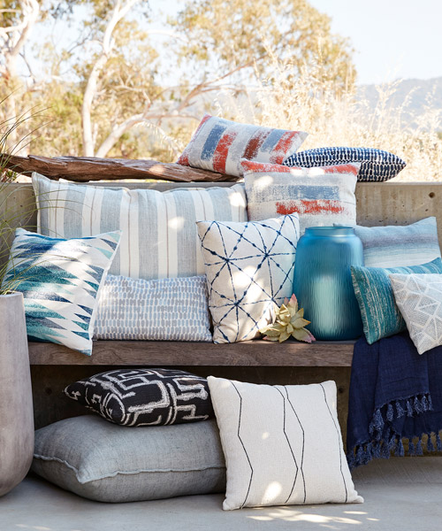 pillows and blankets on furniture bring a splash of color to an outdoor balcony space