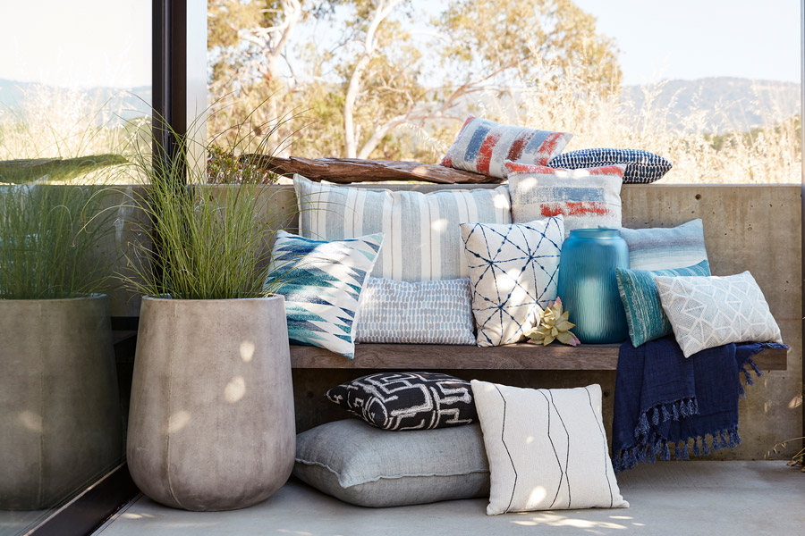 pillows and blankets bring a splash of color to an outdoor balcony space