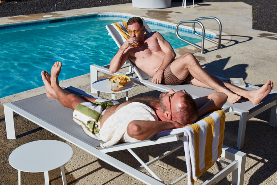 kit and jon lounging poolside with some cold refreshments