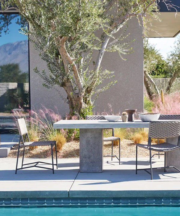 concrete outdoor dining table and woven rope dining chairs