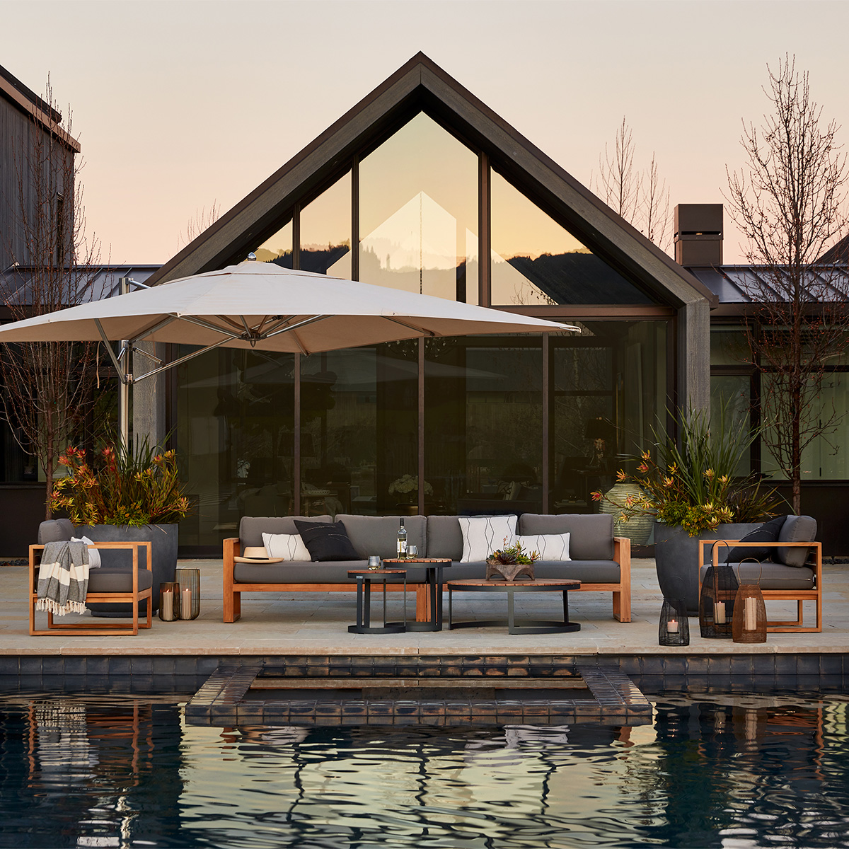 Belvedere sectional seating in teak finish adjacent to pool with TUUCI cantilever providing shade overhead