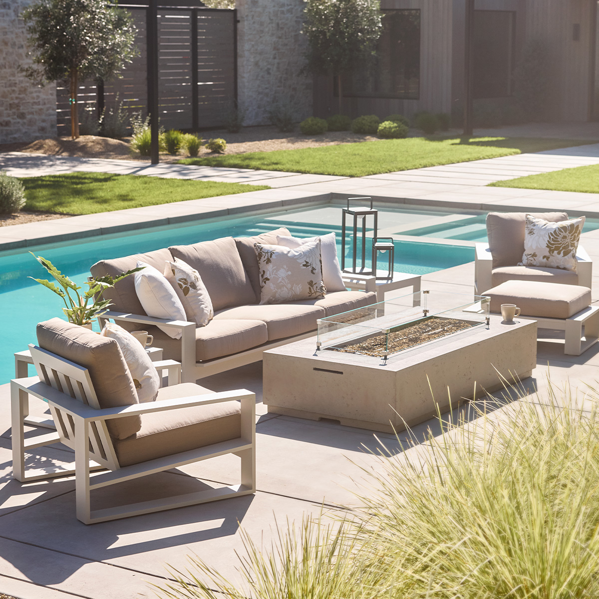 Nicasio lounge seating in dune aluminum finish, positioned around a Legend fire table