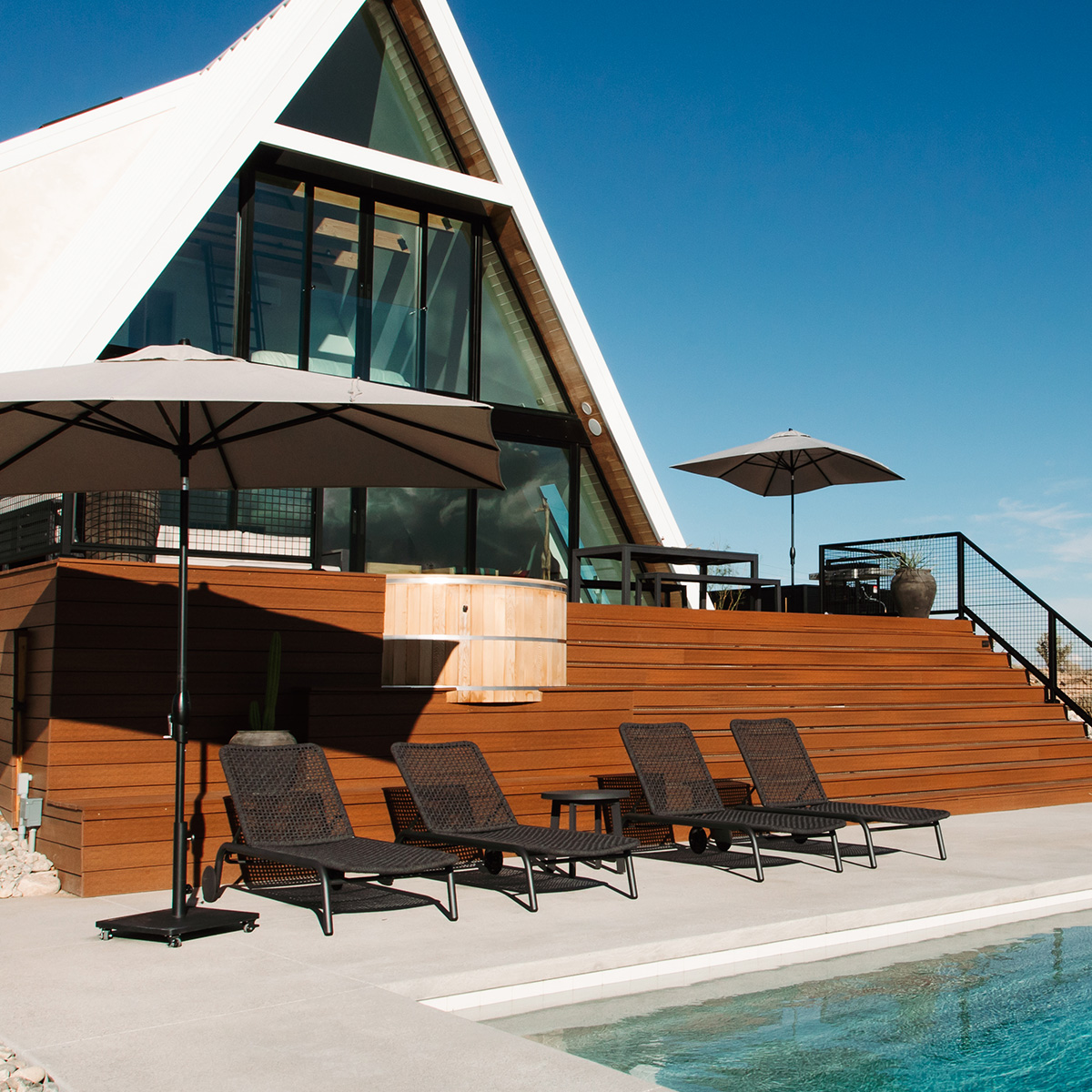 Presidio chaises under a market umbrella at the HATA A-frame property