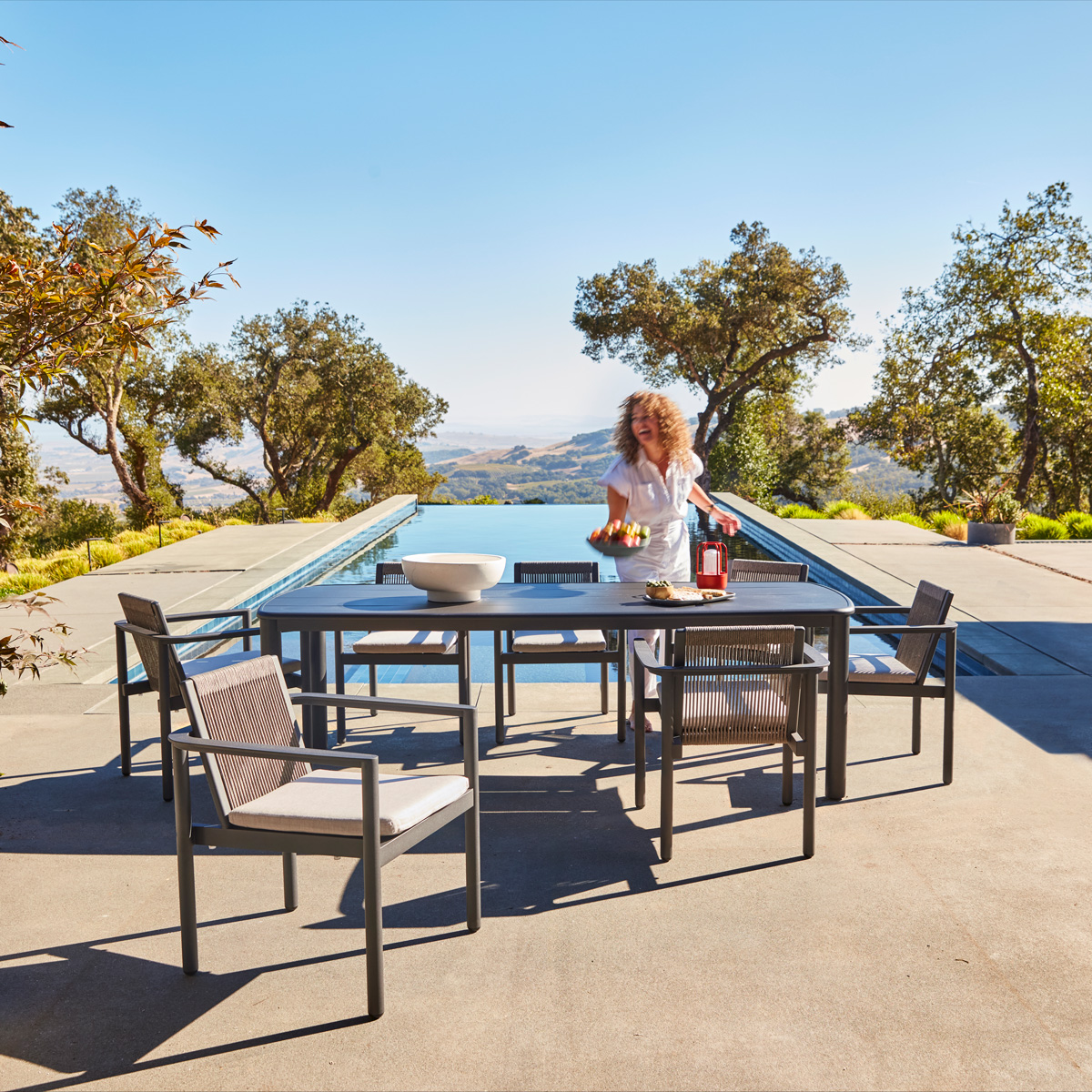 Stinson dining chairs and table in charcoal aluminum by the pool