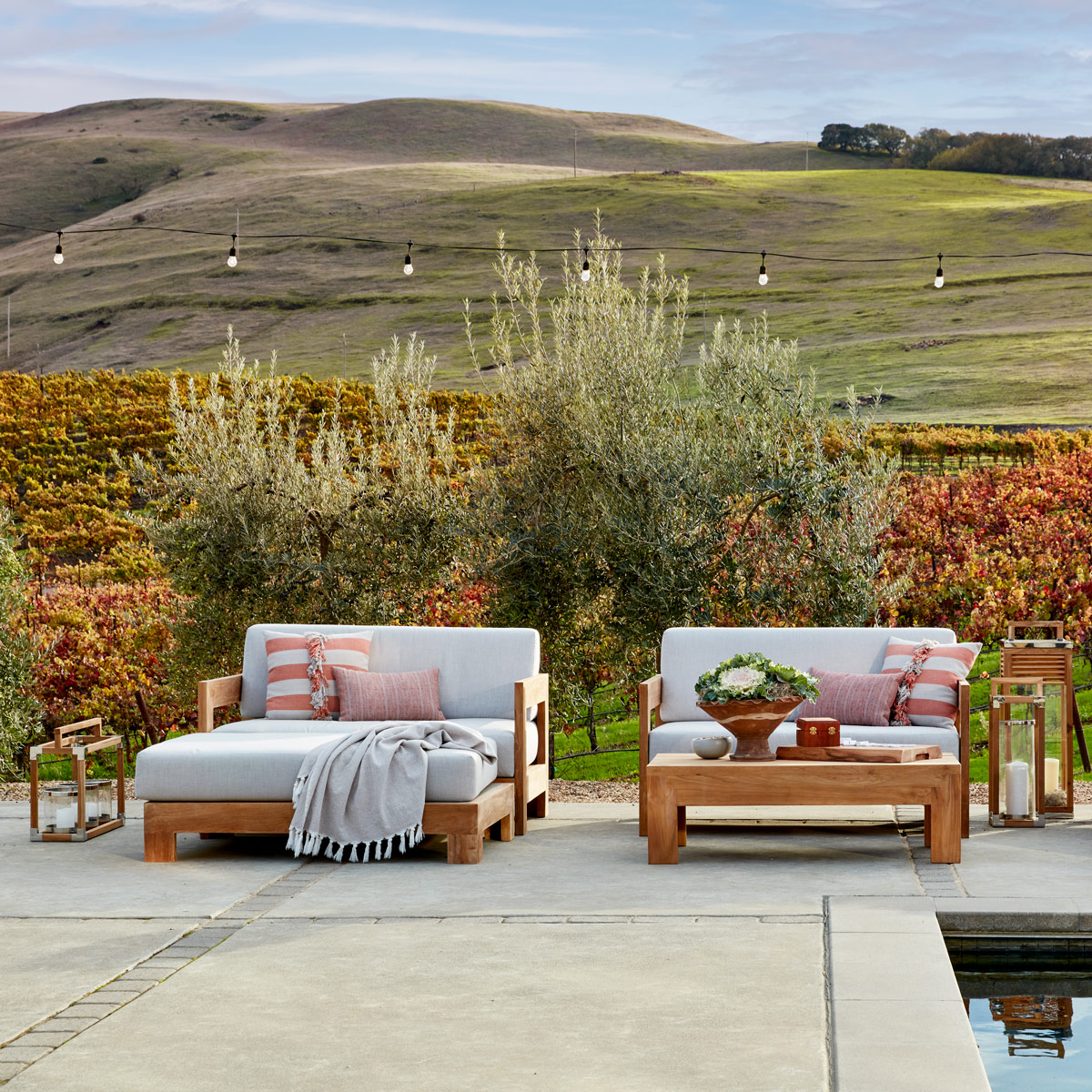 Tiburon teak lounge furniture against the backdrop of rolling hills and grapevines